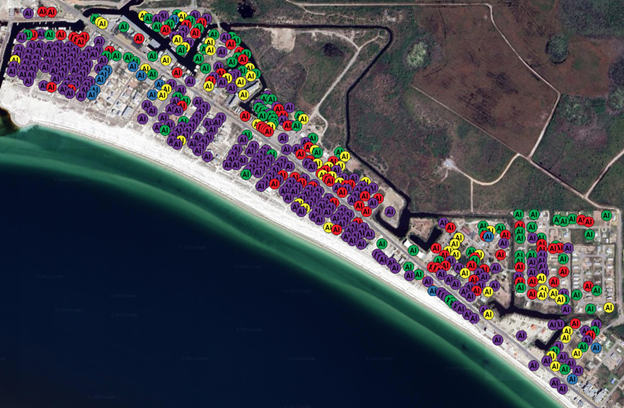 Drone image of a coastline with colorful dots showing types of damage, with the majority marked as "destroyed"
