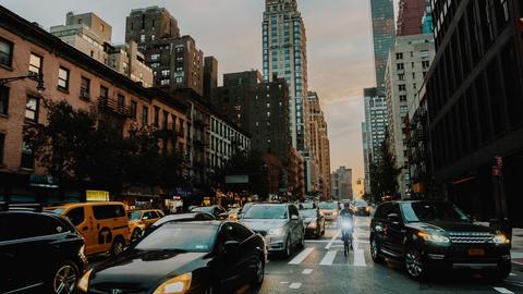 Busy NYC street with biker and taxis