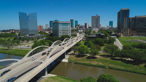 Skyline of Ft Worth with cars driving over a bridge in the foreground
