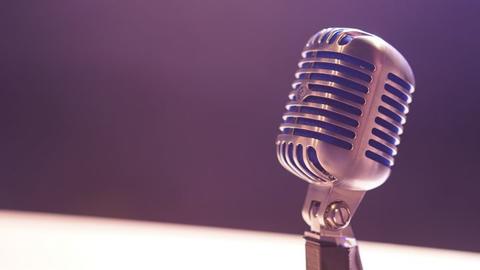 Podcast microphone against a blank background