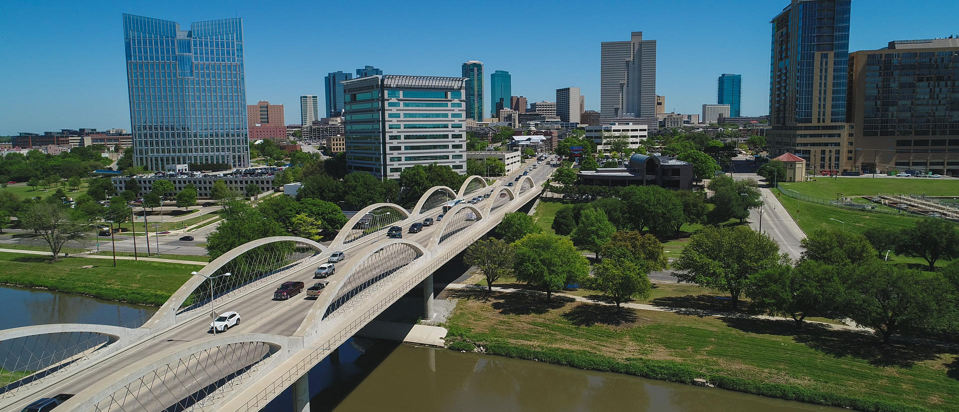 Skyline of Ft Worth with cars driving over a bridge in the foreground