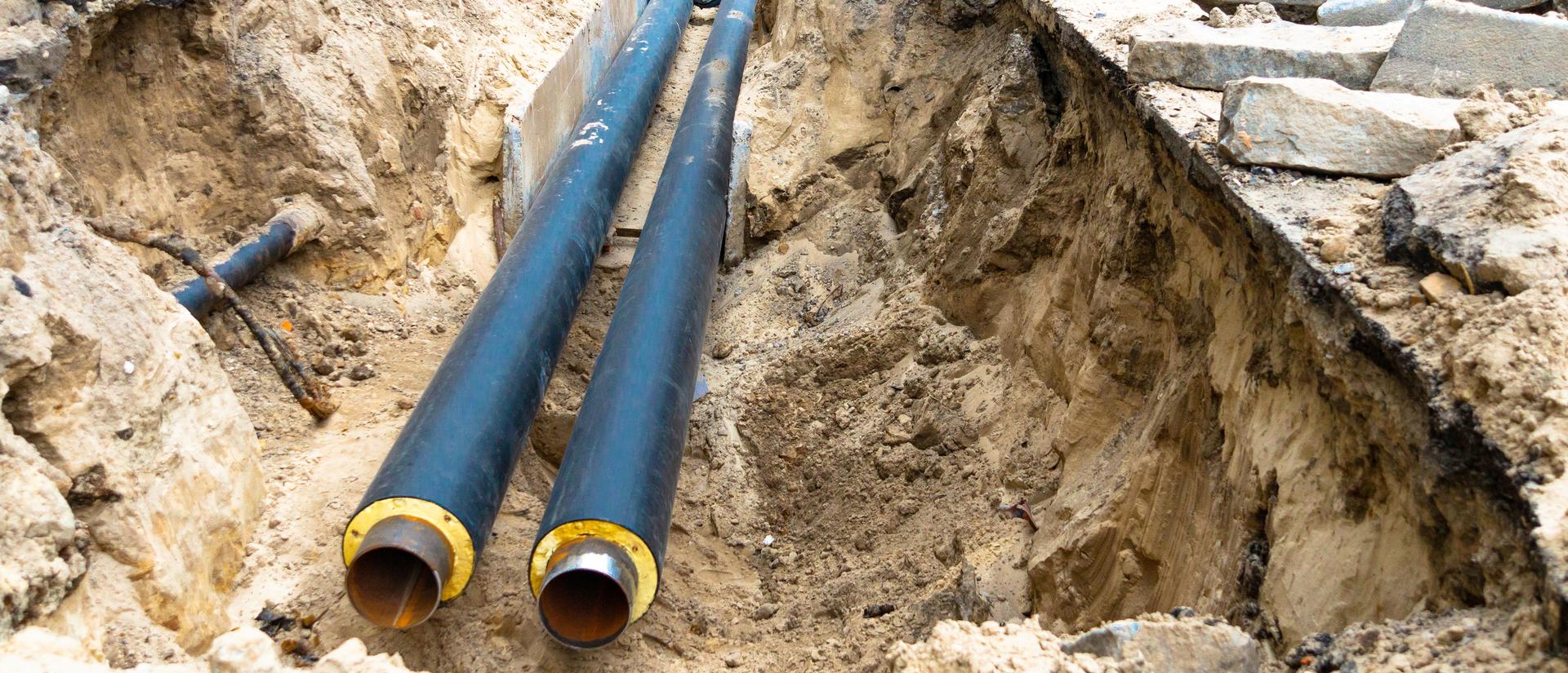 Water main lines in a ground trench for repair