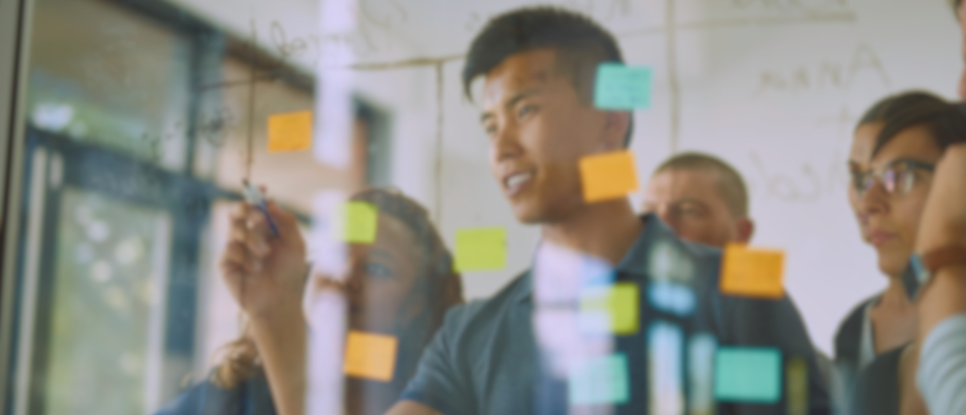 Group of people around a wall of post-it notes