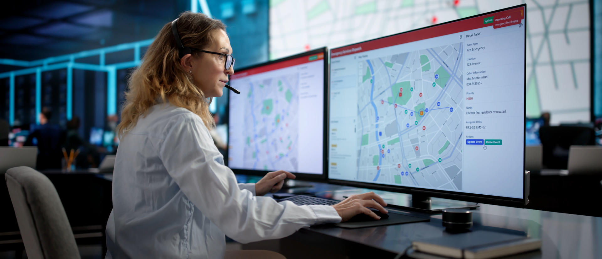 Woman with headset using a computer map to dispatch an ambulance