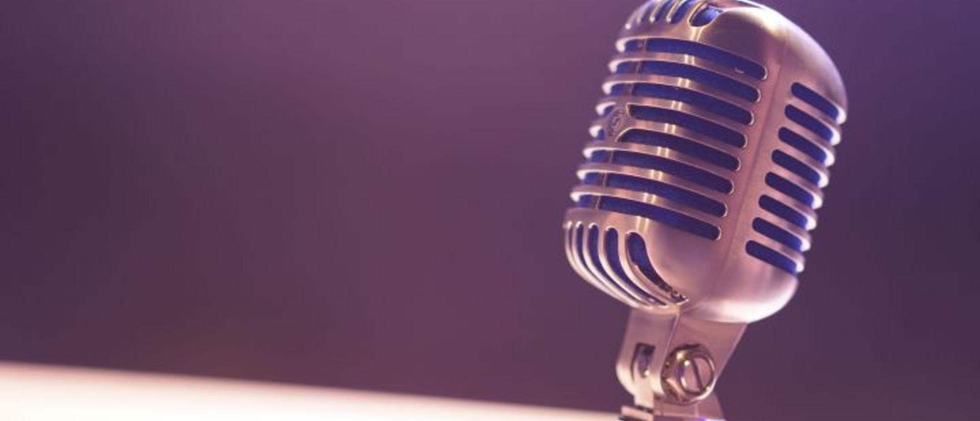 Podcast microphone against a blank background