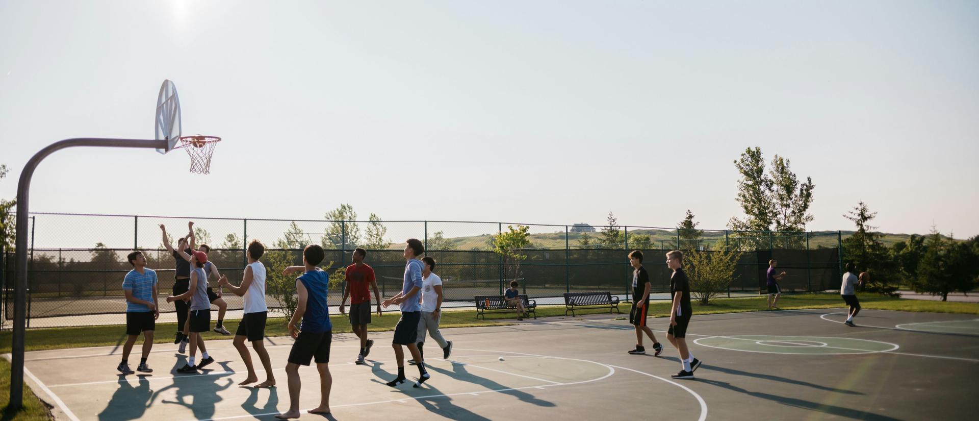 Kids playing basketball on a sunny day