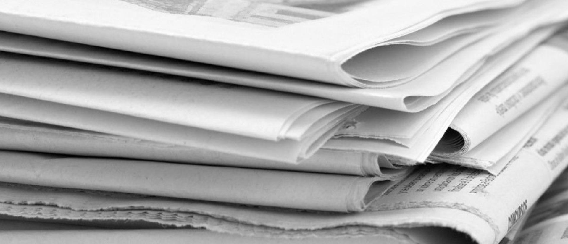 Close up greyscale picture of newspapers